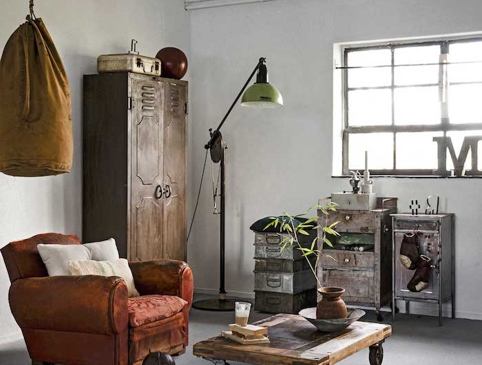 ockerfarbener boxsack roter sessel holztisch mit rädern schränke aus metall industrial style dekoartikel wohnzimmer stilvolle deko inspiration interior design decor trends 2020