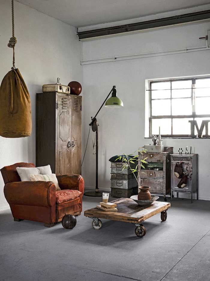 ockerfarbener boxsack roter sessel holztisch mit rädern schränke aus metall industrial style dekoartikel wohnzimmer stilvolle deko inspiration interior design decor trends 2020