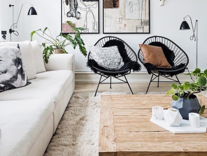 skandinavischer design inneneinrichtung inspiration holztisch mit rädern schwarze stühle weißer couch abstrakte gemälde wanddeko deko wohnzimmer modern interior design minimalistisch