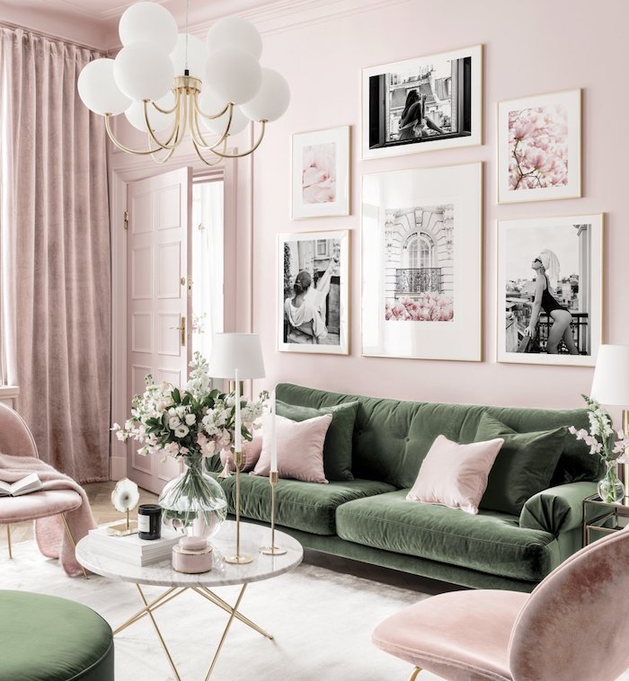 wandfarbe rosa grünes sofa mit pinken und grünen kissen runder tisch vase mit blumen wanddekoration wohnzimmer schwarz weiße fotos moderne inneneinrichtung inspiration
