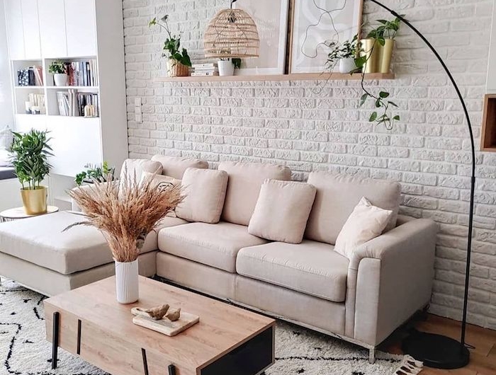 weiße backsteinmauer cremefarbenes ecksofa holzboden gemütliches wohnzimmer modern einrichten stylischer kaffeetisch aus holz modische inneneinrichtung inspo