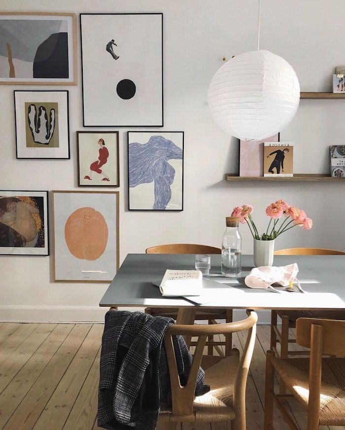 wohnzimmer mit essbereich wohnzimmerwand ideen inspiration moderne abstrakte bilder vase mit pinken blumen offene regale weiße hängende lampe minimalistische interior einrichtung