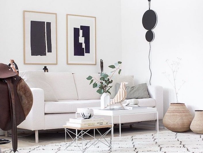 wohnzimmer modern einrichten abstrakte schwarze gemälde eleganter weißer couch skandinavische deko figuren vogel vase mit grünen zweigen weißer teppich