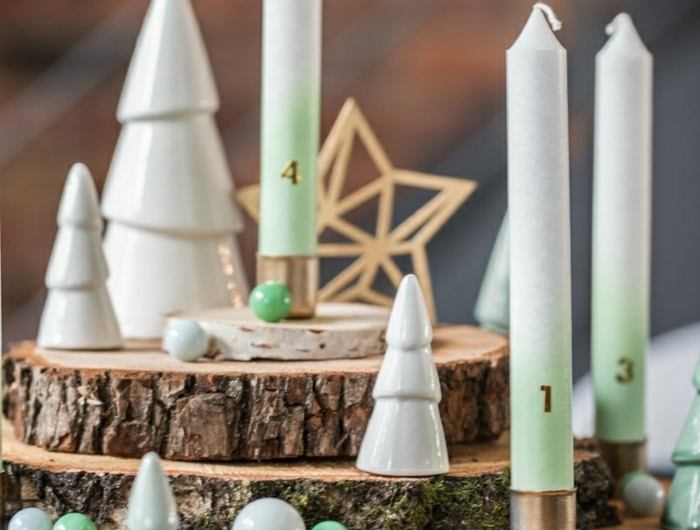 adventskranz baumscheiben vier kerzen weiße tannenbäume keramik kleine kugeln weiß grün