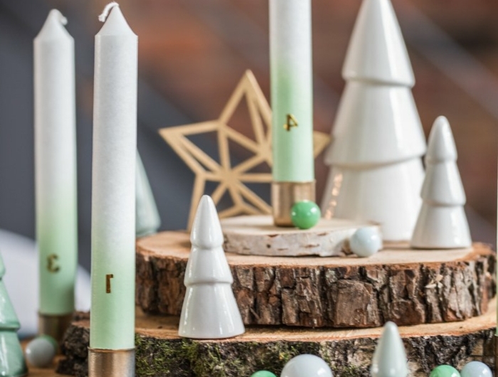 adventskranz baumscheiben vier kerzen weiße tannenbäume keramik kleine kugeln weiß grün