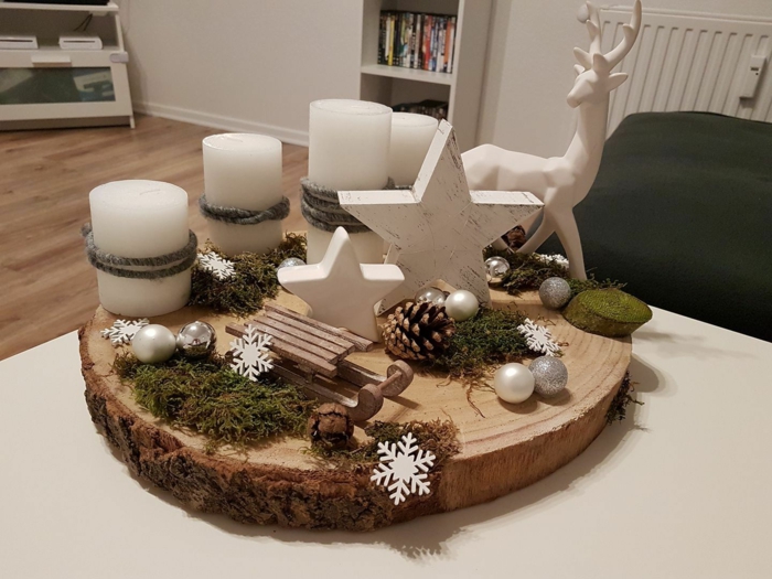 adventskranz selber machen baumscheibe vier weiße kerzen große hirsche keramik holz schlitten kleine kugeln sterne flocken moos