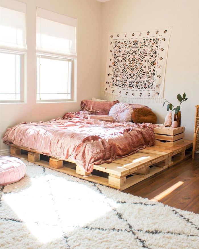 boho deko schlafzimmer großes holzbett auf dem boden boho bettwäsche rosa wanddeko tuch boho motive