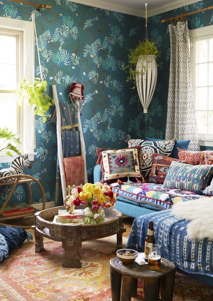 boho style einrichtung wohnzimmer turkisblaue wände blaues sofa bunte kissen holztisch pflanzen hängen