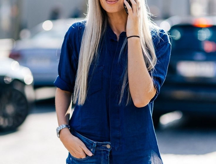 die designerin sarah harris eine frau mit langen grauen haare und mit jeans und einem smartphone