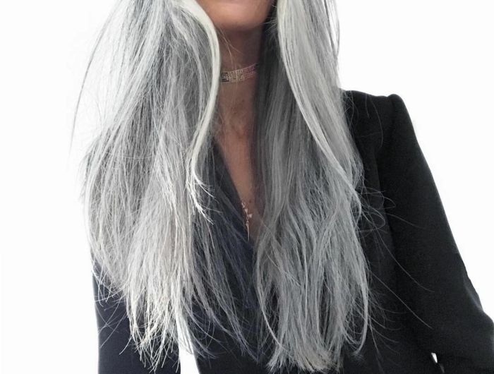 frau mit brille und langen grauen haare und einem schwarzen sakko tipps für pflege von grauen haaren