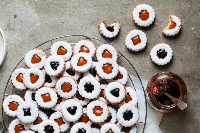 linzer kekse mit marmelade verschiedene sorte spitzbuben mit mandeln bestreut mit puderzucker einmachglas mit aprikosenmarmelade
