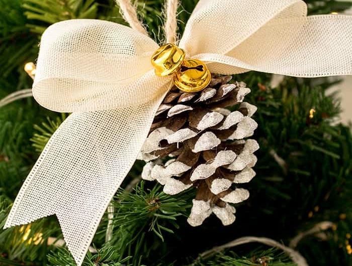 tannezapfen mit weißer schleife und kleiner glocke dekoration weihnachtsbaum ideen und inspiration
