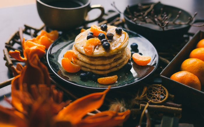 vegane pfannkuchen füllen mit blaubeeren und orangen mandarinen graue tasse