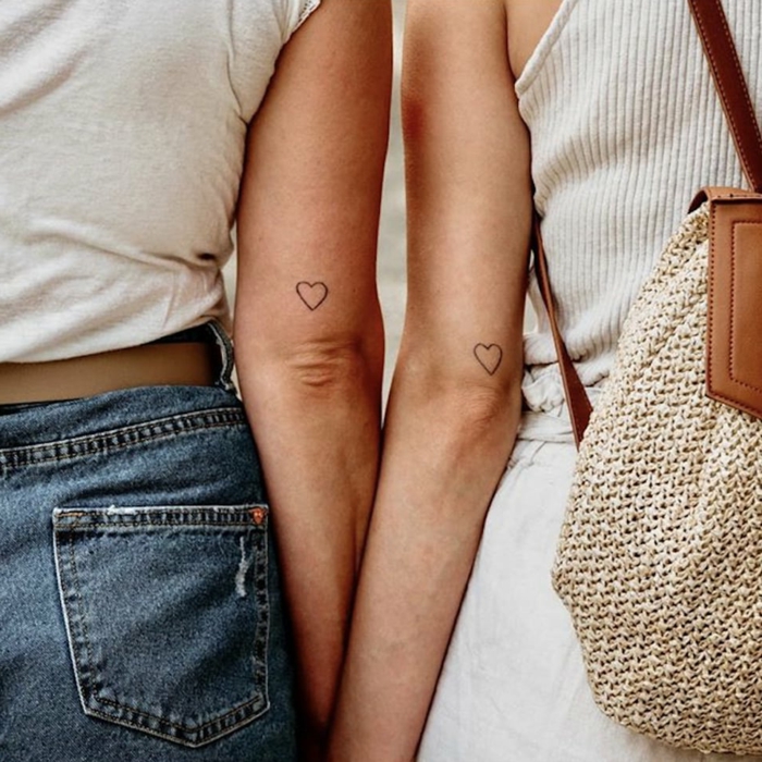 angesagte tattoos tattoo arm freundschaft herzen tätowierung schwarze herzen weißes t shirt jeans gestrickter rucksack