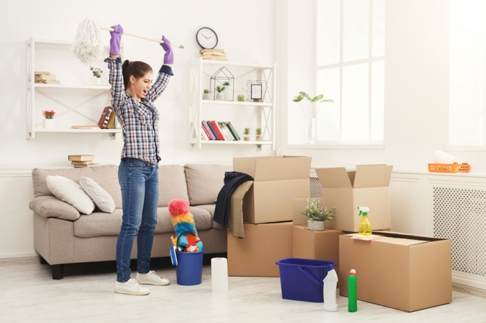 young woman ready to clean her new apartment after moving