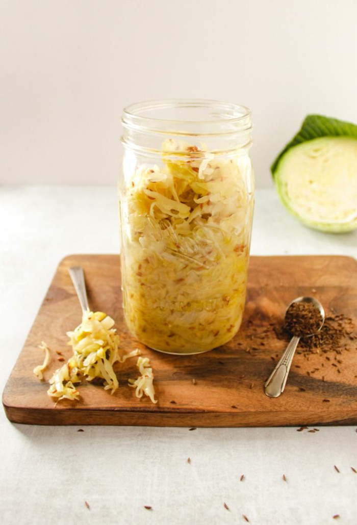 großen einmachglas mit sauerkraut zubereiten rezept gesunde ernährung und rezepte schneidebrett holz löffel mit gewürz