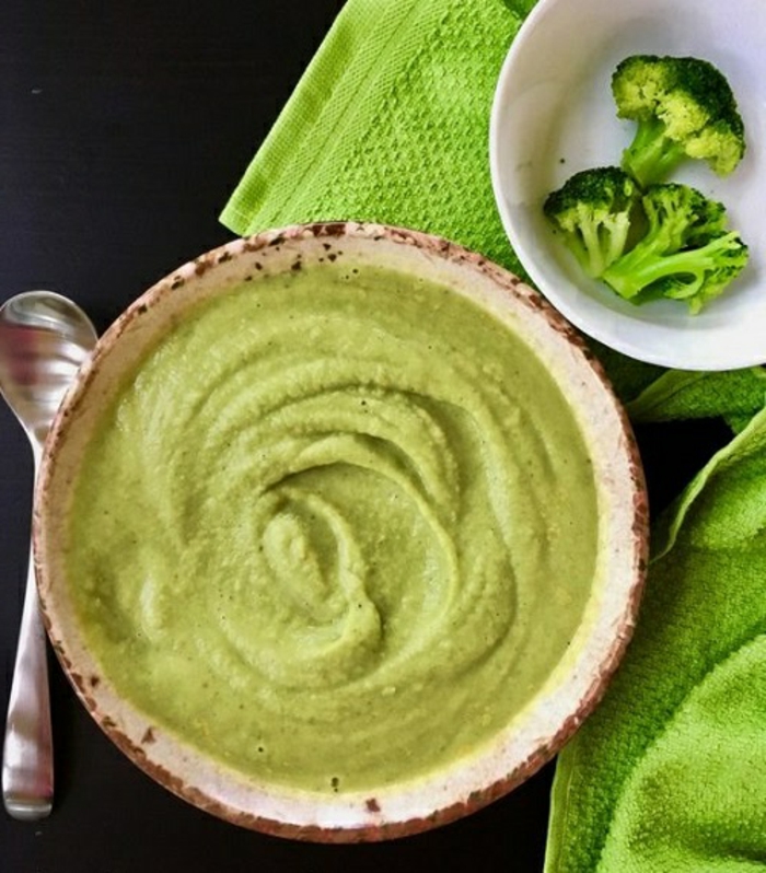 grüne suppe mit brokkoli und mit frischen petersilienblätern ein löffel eine grüne decke