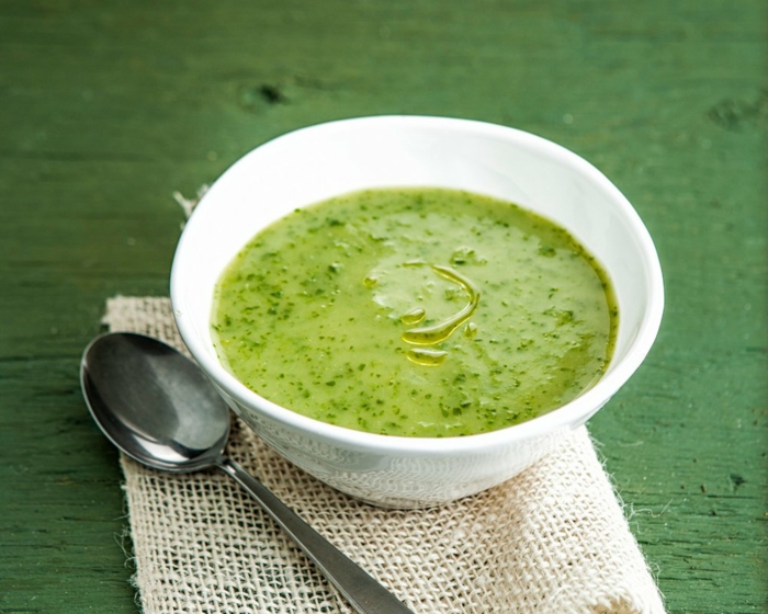 grüner tisch aus holz ein löffel eine suppe mit petersilie kartoffeln und kokosmilch