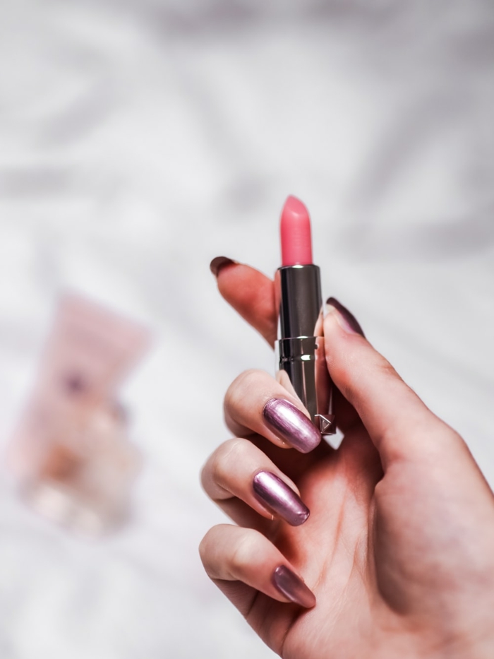 massage auf dem gesicht entspannung schönheit jade roller jung bleiben hand frau lippenstift rosa