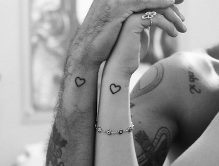 paar mit vielen tattoos schwarz weißes foto symbole für stärke kraft mut tattoos kleine schwarze herze