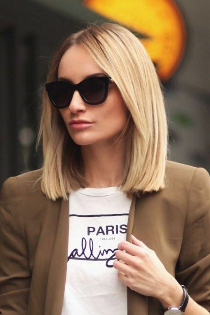 schicker street style dame in brauner jache long bob frisuren 2020 kurzhaarfrisuren blonde haare schwarze sonnenbrillen