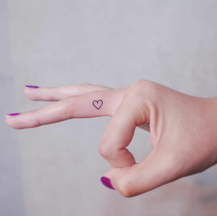 schöne maniküre lila lackierte fingernägel kleines herz tattoo am mittelfinger kleine tattoos frauen
