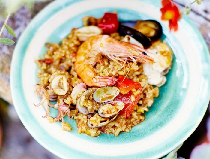 abendessen inspiration paella mit meeresfrüchten reisgerichte ideen spanische gerichte zubereiten rote blume große garnelle