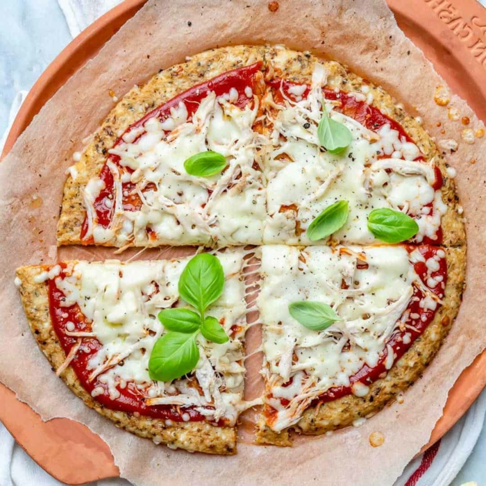 blumenkohl rezepte eine blumenkohl pizza mit basilikum blättern und käse und tomaten
