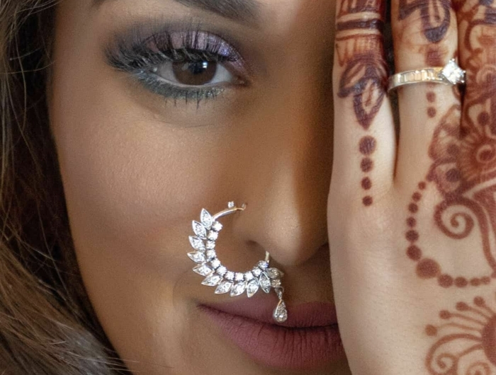 braune augen henna tattoo auf der hand frau mit braunen haare großes nasenring piercing indische kultur inspo