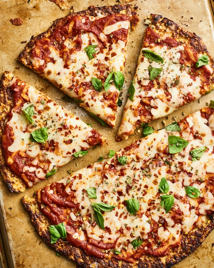 ein holzbrett eine blumenkohl pizza mit käse und petersilie und tomaten