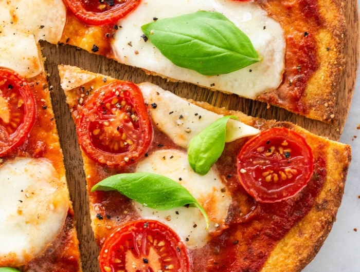 eine pizza mit tomaten und blumenkohl und frischen basilikum blättern