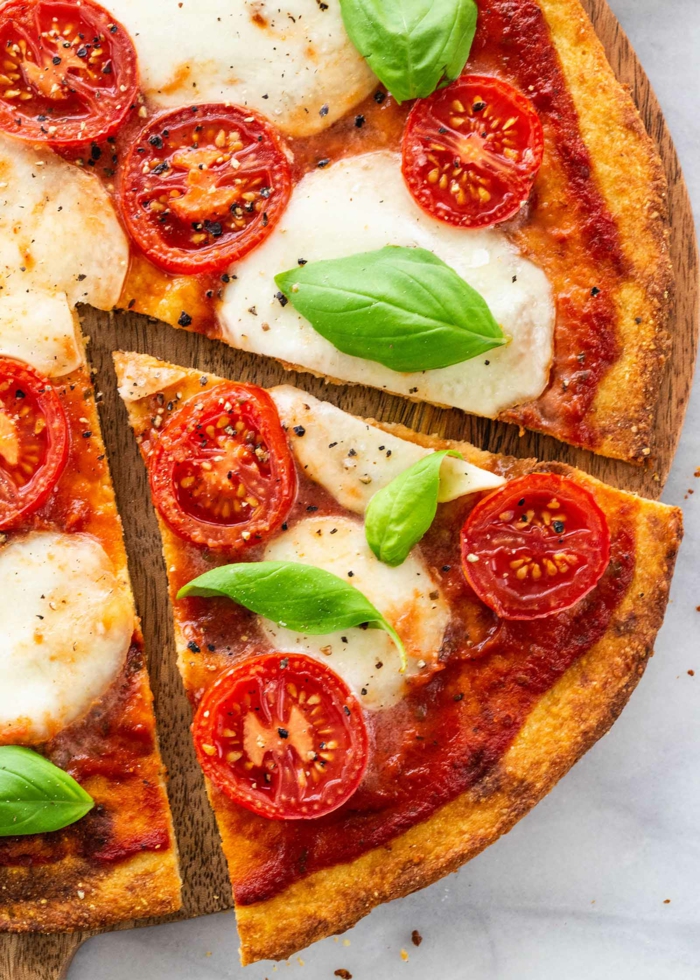 eine pizza mit tomaten und blumenkohl und frischen basilikum blättern