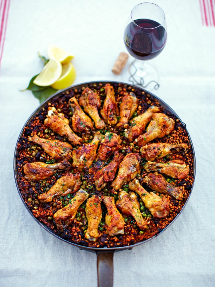 glas mit wein abendessen spanische gericht traditionell hähnchen paella rezept kochen inspiration