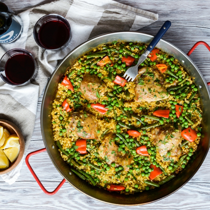 kochen 2021 hähnchen paella mit kichererbsen blaue gabel zwei gläser mit wein spanische gerichte mit reis