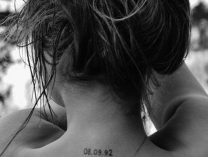 schwarz weißes foto geburtsdatum tattoo am nacken drei geburtstagsdaten frau mit langen haaren