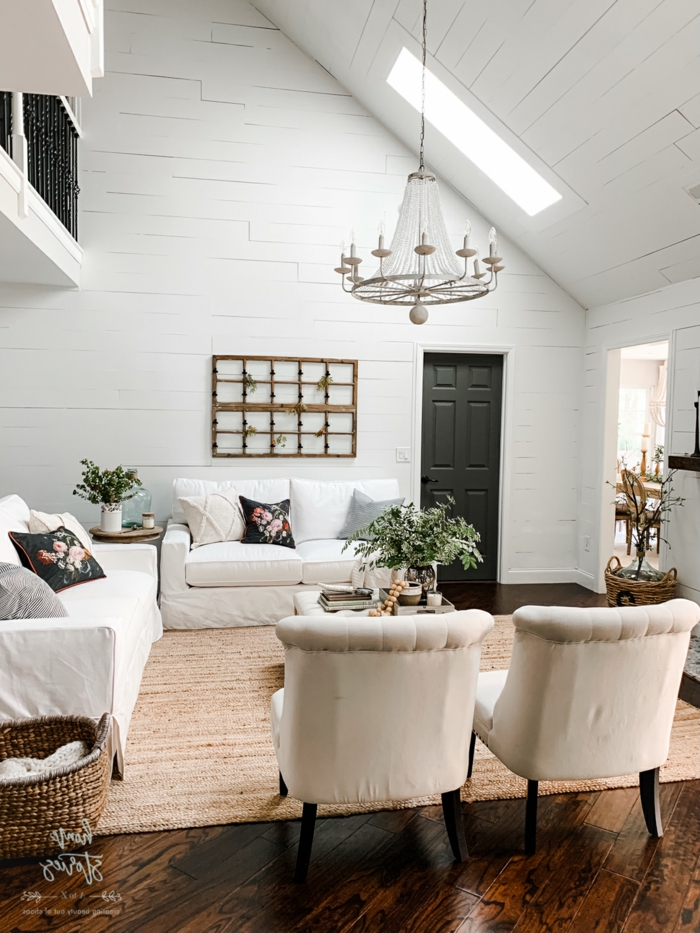 vintage chic wohnzimmer einrichtung weiße sofas und sessel velux dachfenster größen schwarze kissen mit blumen