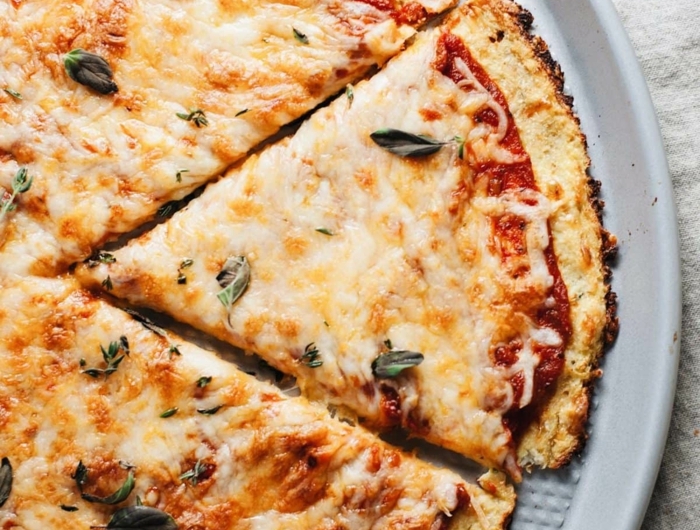 weißer teller mit blumenkohl pizza mit tomaten und champignons