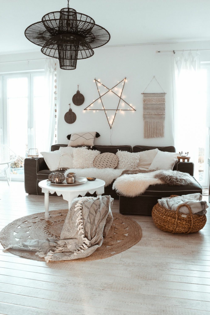 2021 interior design gemütliches wohnzimmer modern einrichten im hygge style skandinavische inspiration innenausstattung viele deko kissen stern wandlampe schwarzes ecksofa