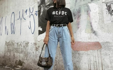 ac dc t shirt schwarz klassisches outfit street style hellblaue jeans damen slouchy style schwarze boots und tasche dame mit kurzen haaren