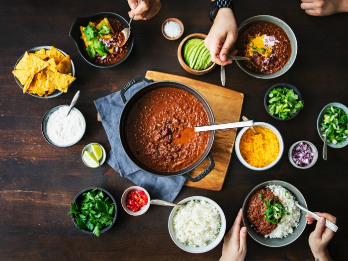 brett aus holz hände mexikanisches gericht paprikaschoten chilischoten chili con carne rezept