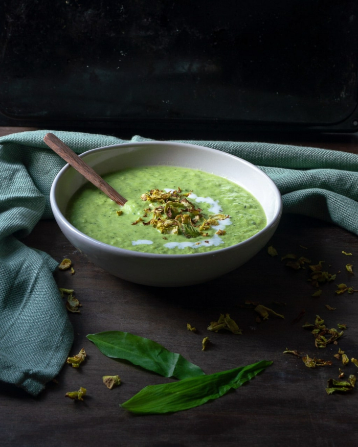 eine grüne vegane passierte suppe mit bärlauch eine weiße schüssel mit sahne suppe mit wild garlic