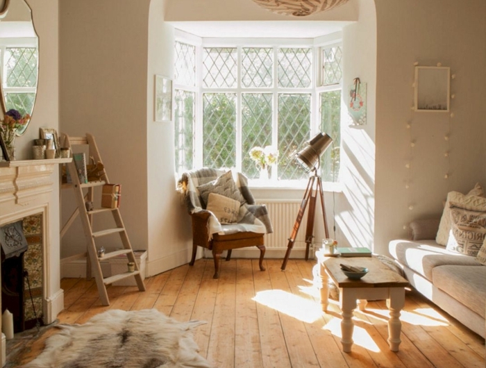 große fenster mit weißen rahmen holzboden wohnzimmer hygge möbel minimalistische schlichte einrichtung flauschiger kleiner teppich
