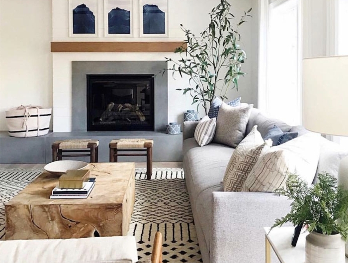 großes wohnzimmer skandinavischer stil großes sofa grau mit deko kissen großes kamin großer tisch aus holz