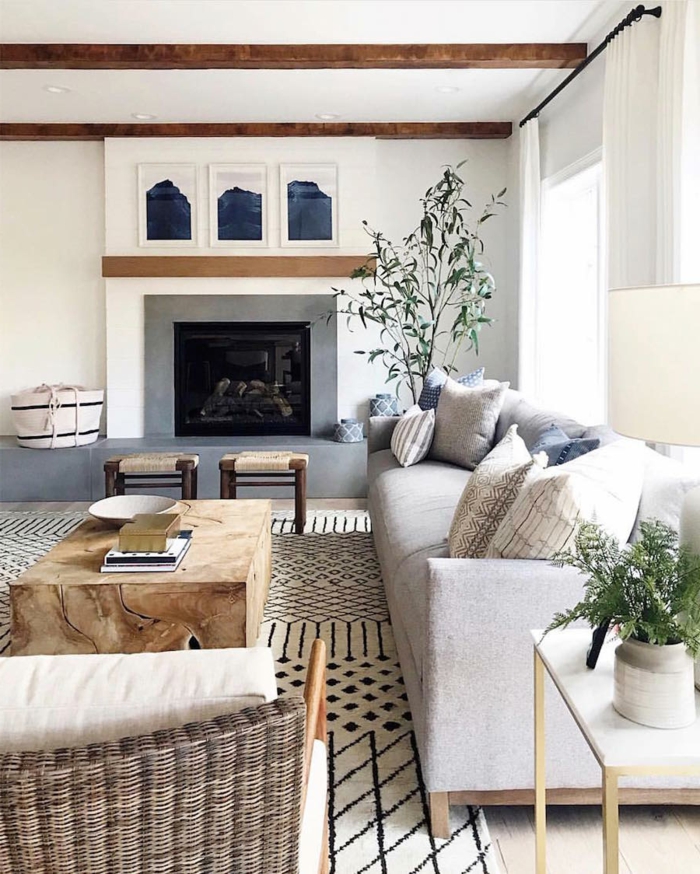 großes wohnzimmer skandinavischer stil großes sofa grau mit deko kissen großes kamin großer tisch aus holz
