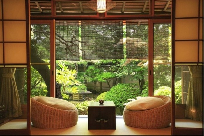 japanischer einrichtungsstil wabi sabi wohnen japanische inneneinrichtung wabi sabi sessel aus stroh teetisch klein schwarz garten grünen pflanzen