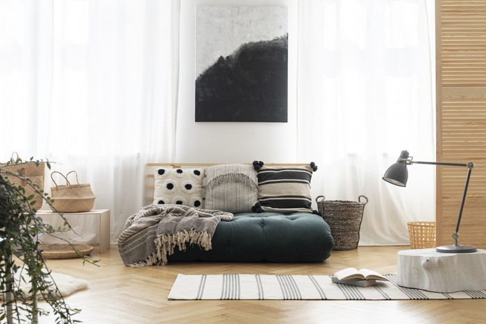 japanischer minimalismus japanisches wohnzimmer einrichten wabi sabi interior japanisches einrichtungsstil wabi sabi großes sofa dunkelgrau mit kissen wandbild stehlampe holzboden