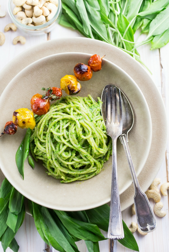 löffel und gabel ein weißer teller grüne spaghetti mit bärlauch gesund