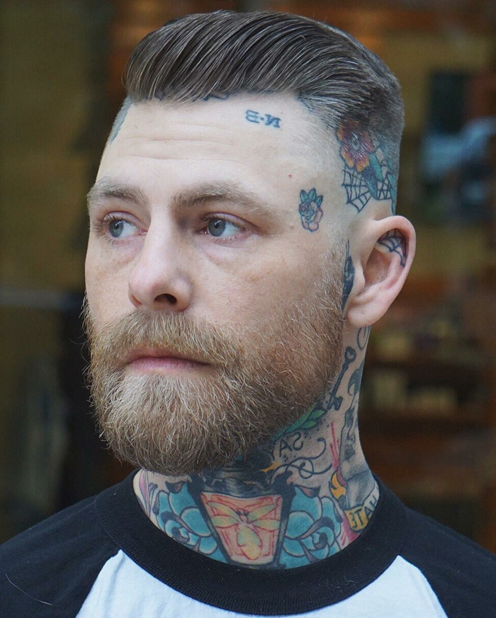 mann mit vielen farbigen tattoos kurzer haarschnitt seiten auf null mit üergang herren kurzhaarfrisuren mit bart dunkelblonde haare