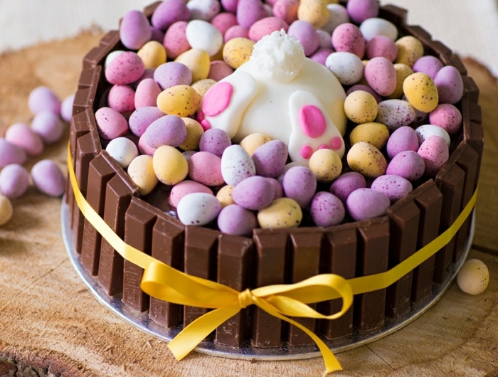 ostern backen eine torte aus schokolade und vielen kleinen gelben und violetten und pinken oster eiern