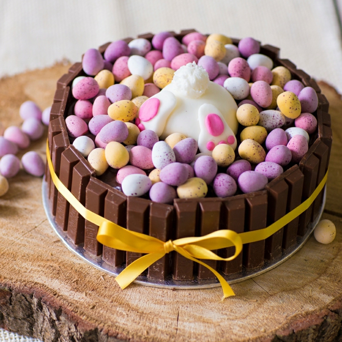 ostern backen eine torte aus schokolade und vielen kleinen gelben und violetten und pinken oster eiern